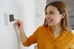 Ragazza che regola il termostato di casa