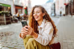 Ragazza che sorride e scrive al cellulare