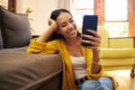 Ragazza che sorride mentre usa il cellulare