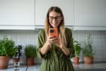 Ragazza che sorride mentre usa il suo smartphone