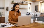 Ragazza seduta al tavolo che utilizza il computer 