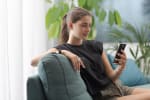 ragazza con lo smartphone sul divano