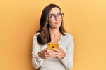 ragazza con smartphone su sfondo giallo