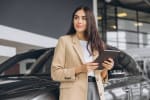 ragazza con tablet vicino ad un'auto