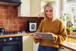 ragazza consulta il tablet in cucina