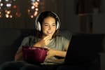 ragazza guarda tv su computer con popcorn