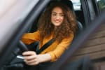 Ragazza seduta in auto con le mani sul volante