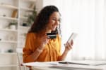 Ragazza sorridente con carta di credito in mano 