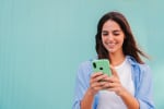 Ragazza su sfondo verde usa smartphone