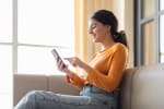 ragazza usa lo smartphone seduta sul divano