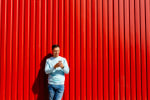 Ragazzo con smartphone e sfondo rosso
