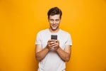 Ragazzo con smartphone su sfondo arancione