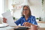 Signora che controlla la pensione effettuando dei calcoli