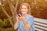 signora seduta all'aperto con il cellulare