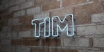 Logo TIM neon su muro di mattoni