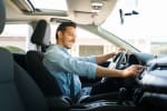 Uomo al volante che usa touchscreen della macchina