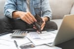 Uomo che controlla il portafoglio mentre calcola le spese