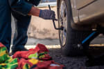 Uomo che monta le gomme dell'auto estive 