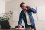 Uomo che parla al telefono mentre scrive
