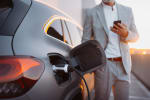 uomo che ricarica la sua auto elettrica 