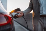Uomo che ricarica l'auto elettrica alla colonnina
