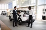Uomo che sceglie suv elettrico in concessionaria