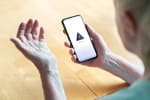 Uomo che tiene in mano uno smartphone che non funziona