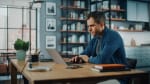 Uomo che usa il computer alla scrivania di casa