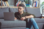 uomo con laptop sul divano