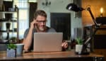 Uomo con occhiali alla scrivania lavora al computer