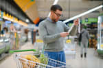uomo controlla scontrino al supermercato