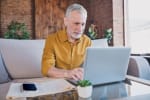 Uomo di età avanzata che lavora a pc