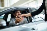 Uomo in auto che riceve le chiavi della macchina