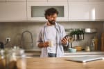 uomo in cucina con smartphone