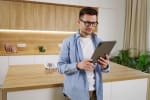 uomo in cucina mentre usa il tablet