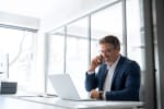 uomo in ufficio al telefono e pc