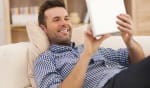 uomo rilassato sul divano con il tablet