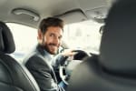 uomo_su_auto_si_gira_verso_il_passeggero_e_sorride