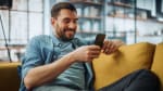 Uomo su divano naviga internet su smartphone