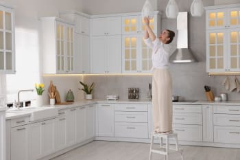 donna cambia lampadine in cucina