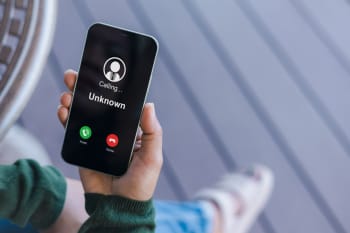 persona tiene in mano smartphone con chiamata anonima