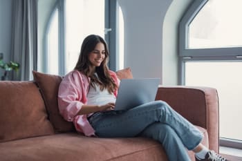 Ragazza al computer sul divano di casa