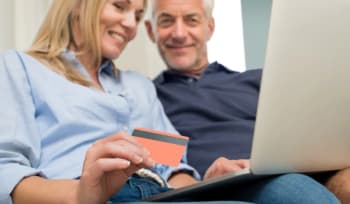 coppia al pc con carta di credito in mano