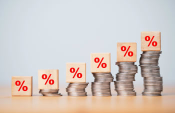 Monete con simbolo percentuale che indica l'andamento degli interessi