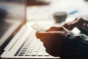 Persona che tiene in mano carta credito