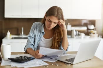 Ragazza guarda bollette preoccupata
