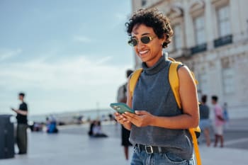 Ragazza usa smartphone in vacanza