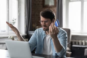 Uomo a pc preoccupato che controlla conto