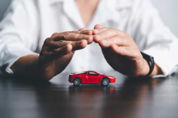 Uomo protegge modellino di auto con le mani