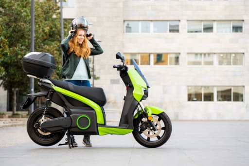 ragazza_si_mette_il_casco_per_salire_su_moto_elettrica ragazza_si_mette_il_casco_per_salire_su_moto_elettrica